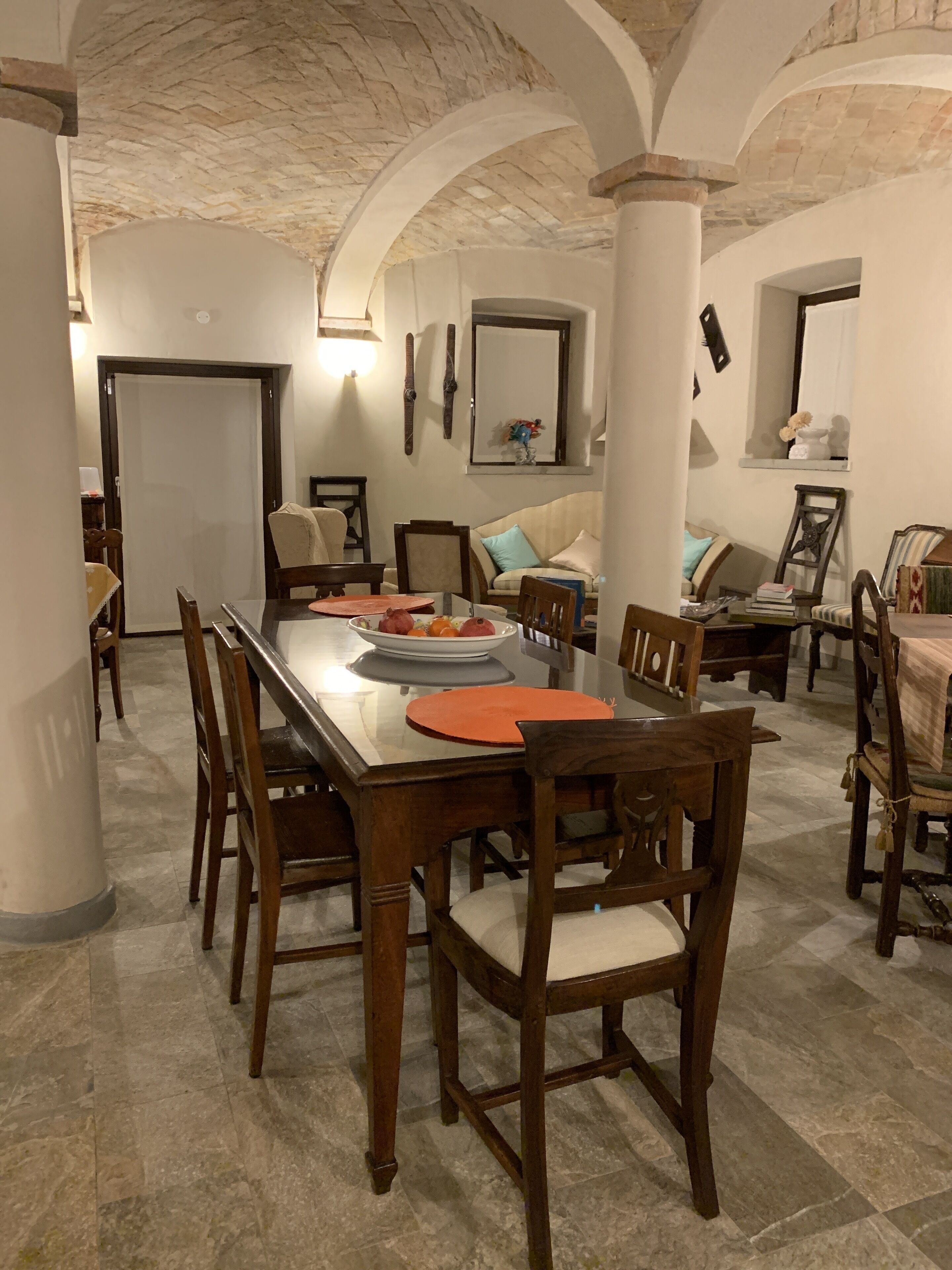 Un comedor con una larga mesa de madera, sillas y una planta en maceta.