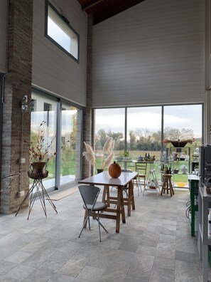 A spacious kitchen with large windows, a dining area, and a view of the outdoors.