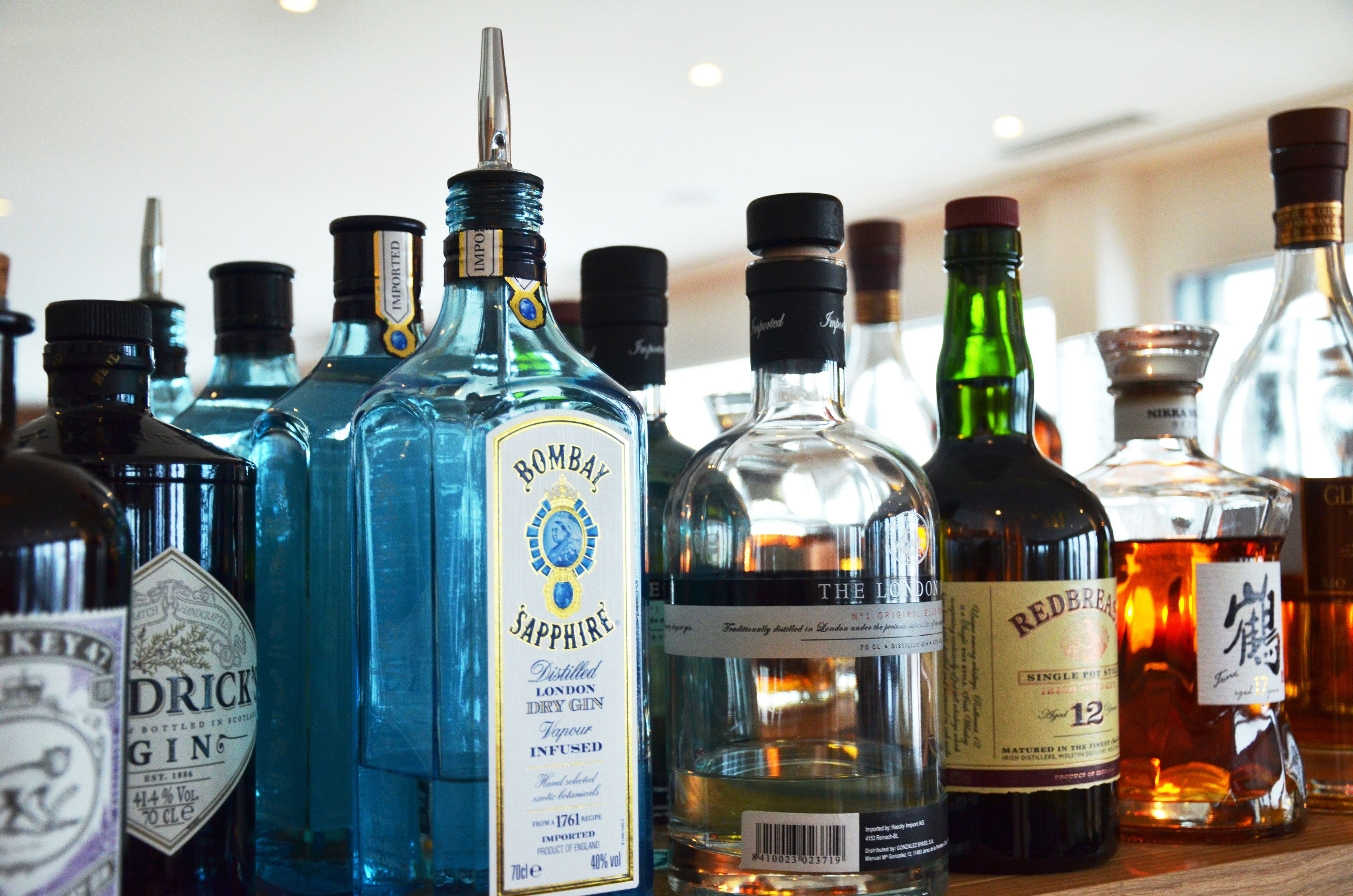 A variety of liquor bottles on a shelf.