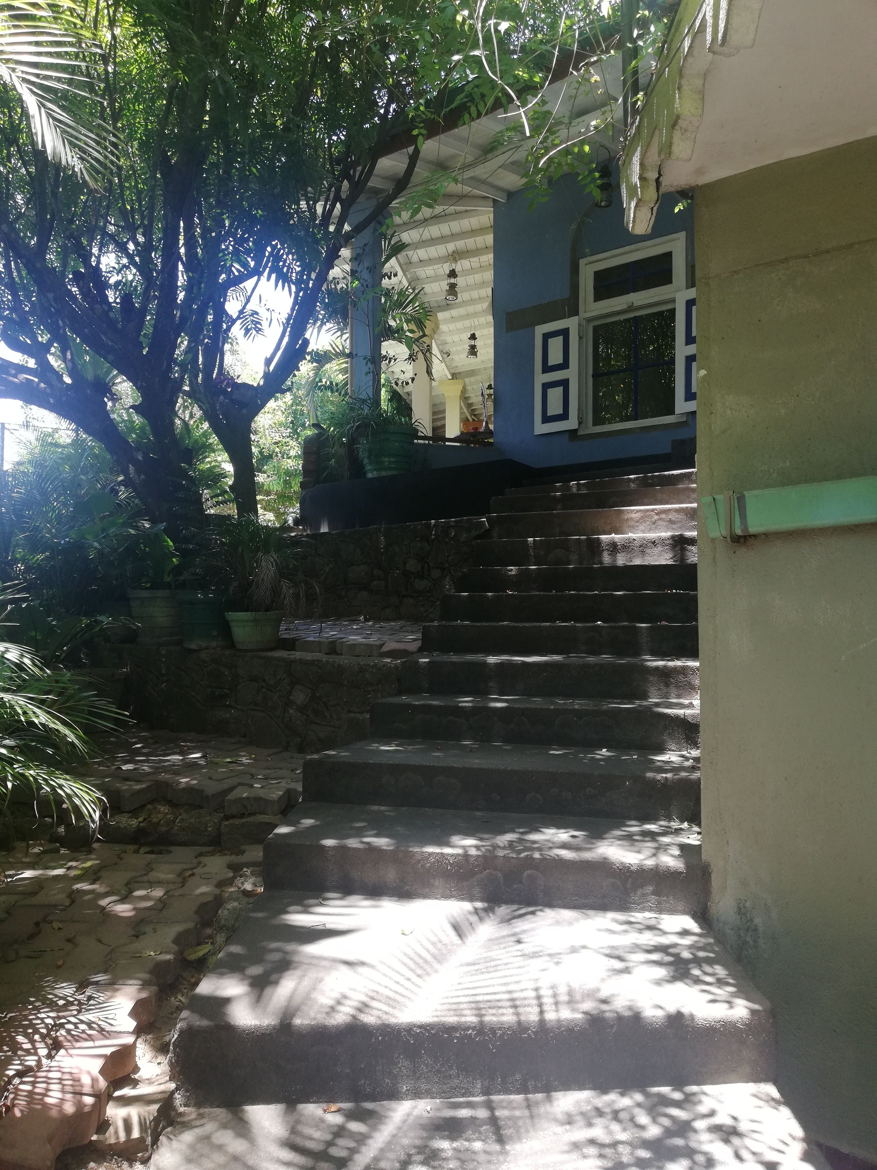 A staircase leading to a porch with a view of a window and a door.