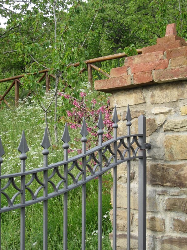 A stone wall with a metal fence.