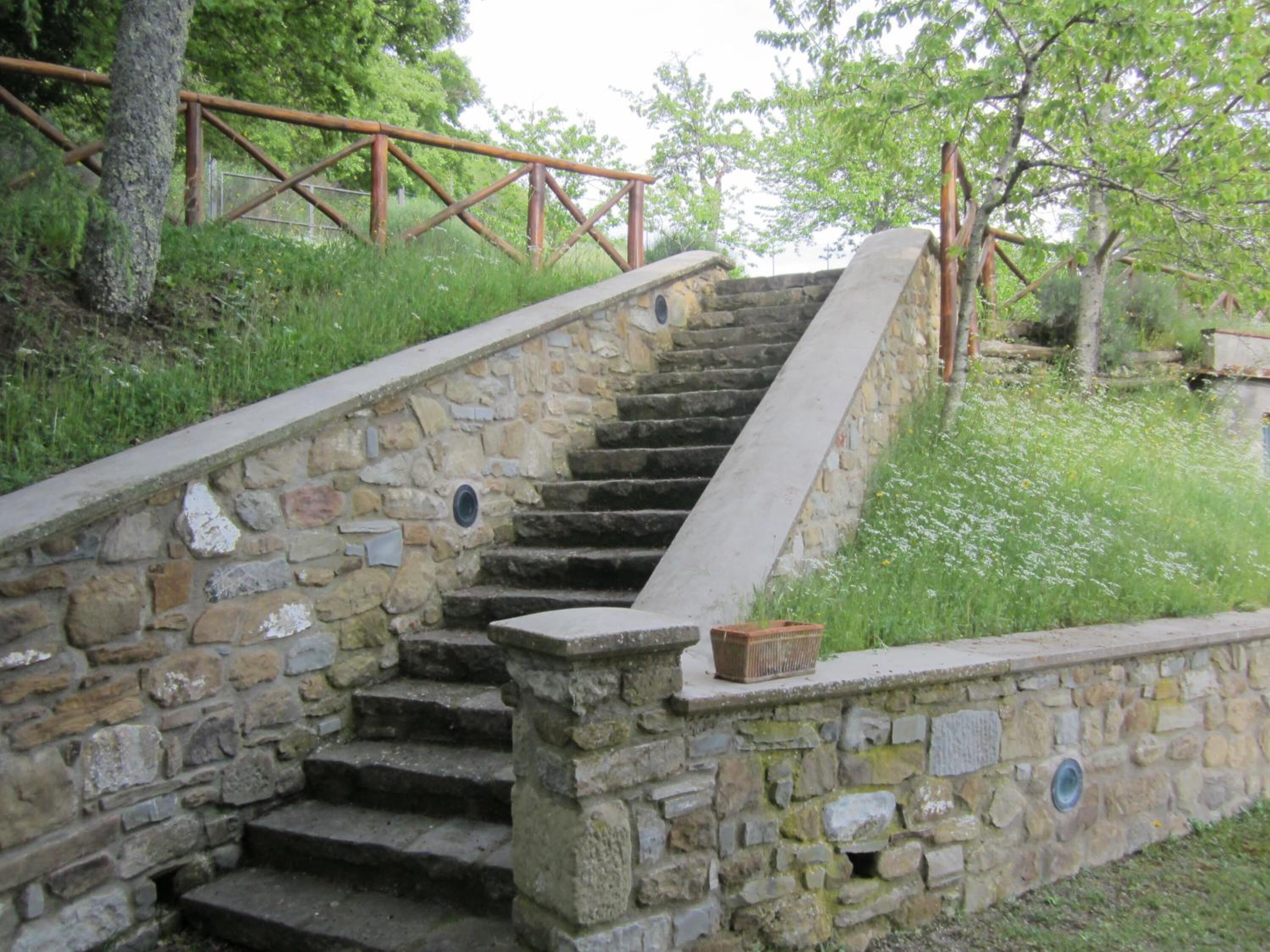 Eine Steintreppe mit Metallgeländern, die zu einer höheren Ebene führt.