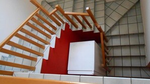 A staircase with wooden handrails and a white box on the landing. - B&B Paradiso (Falerna)