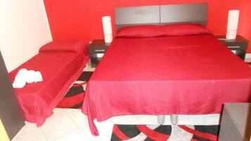 A room with a single bed, a nightstand, and a bedside table.