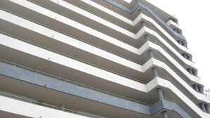 Un edificio de varios pisos con un diseño arquitectónico en zigzag, que presenta balcones y ventanas en cada nivel.