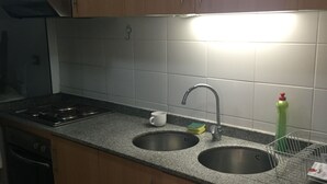 Una cocina con dos lavabos, una estufa y armarios.