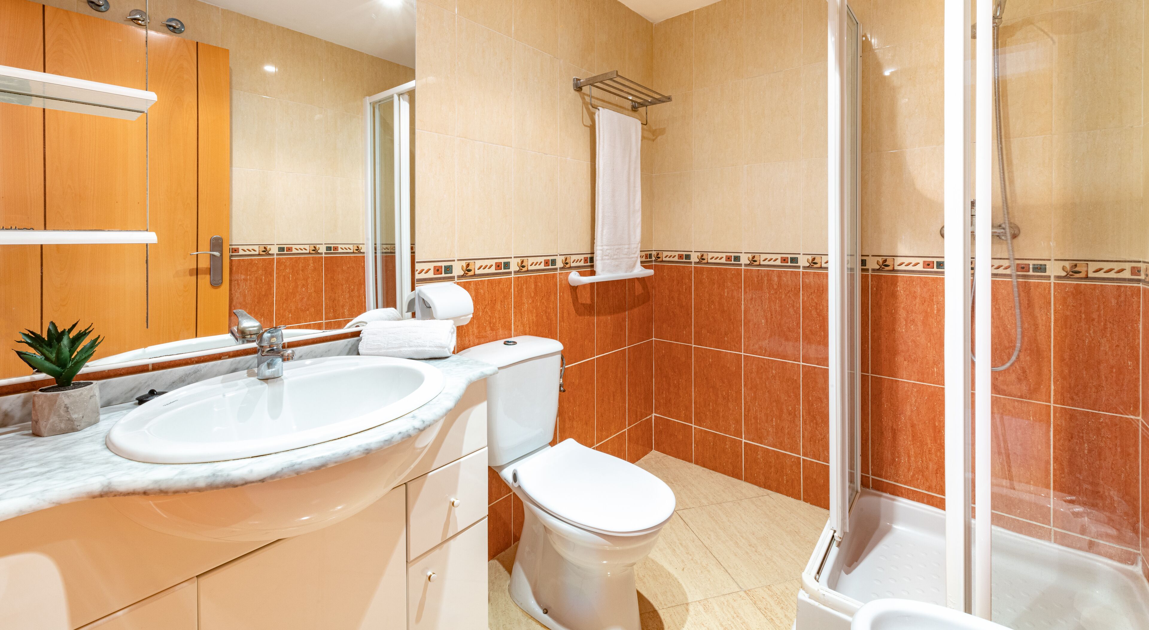 A bathroom with a sink, toilet, and shower.