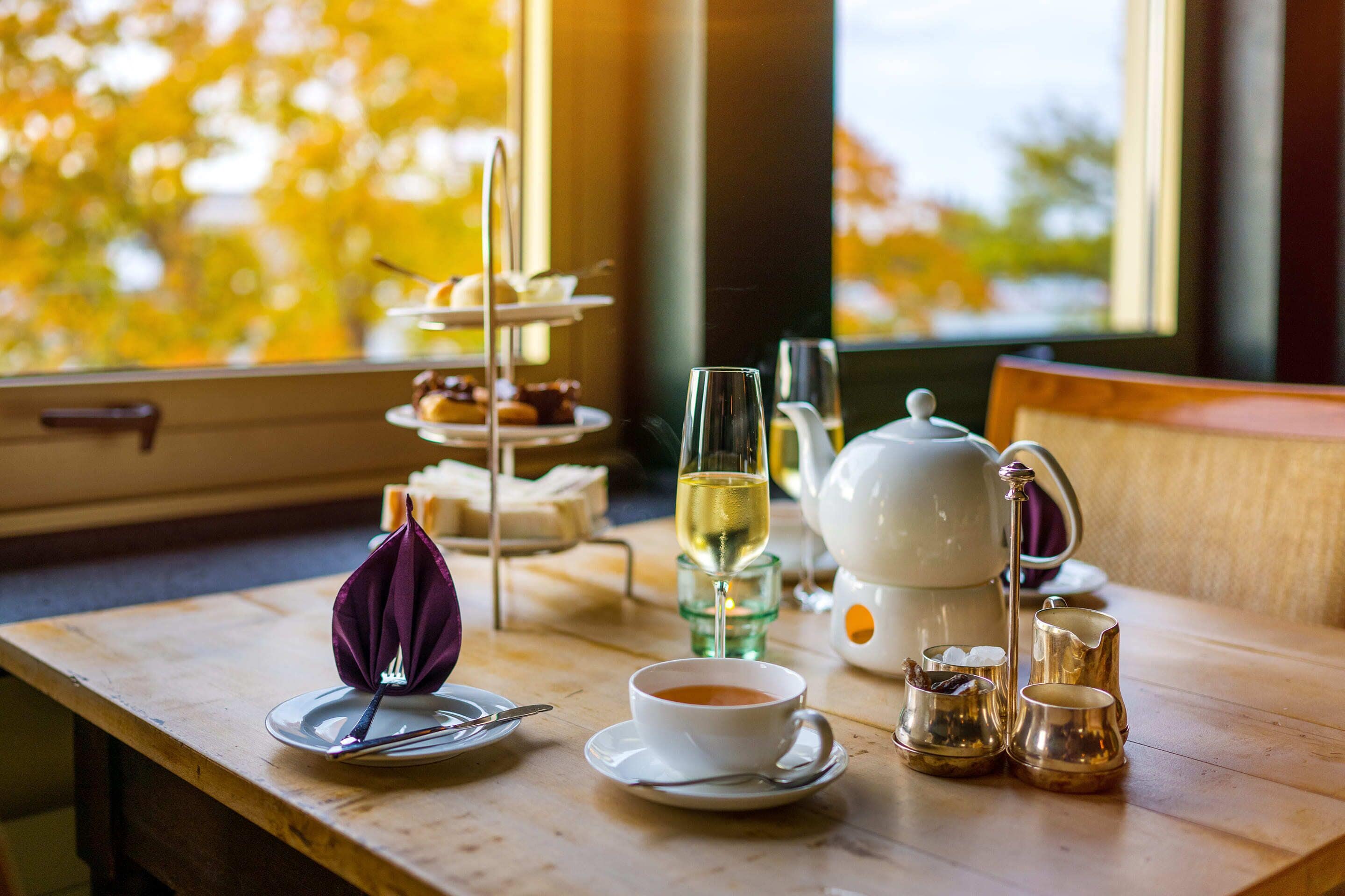 Una mesa dispuesta para el té, con tetera, tazas y terrones de azúcar.