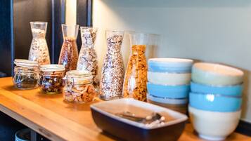 A variety of glass containers and bowls on a wooden table, likely for serving food or drinks.