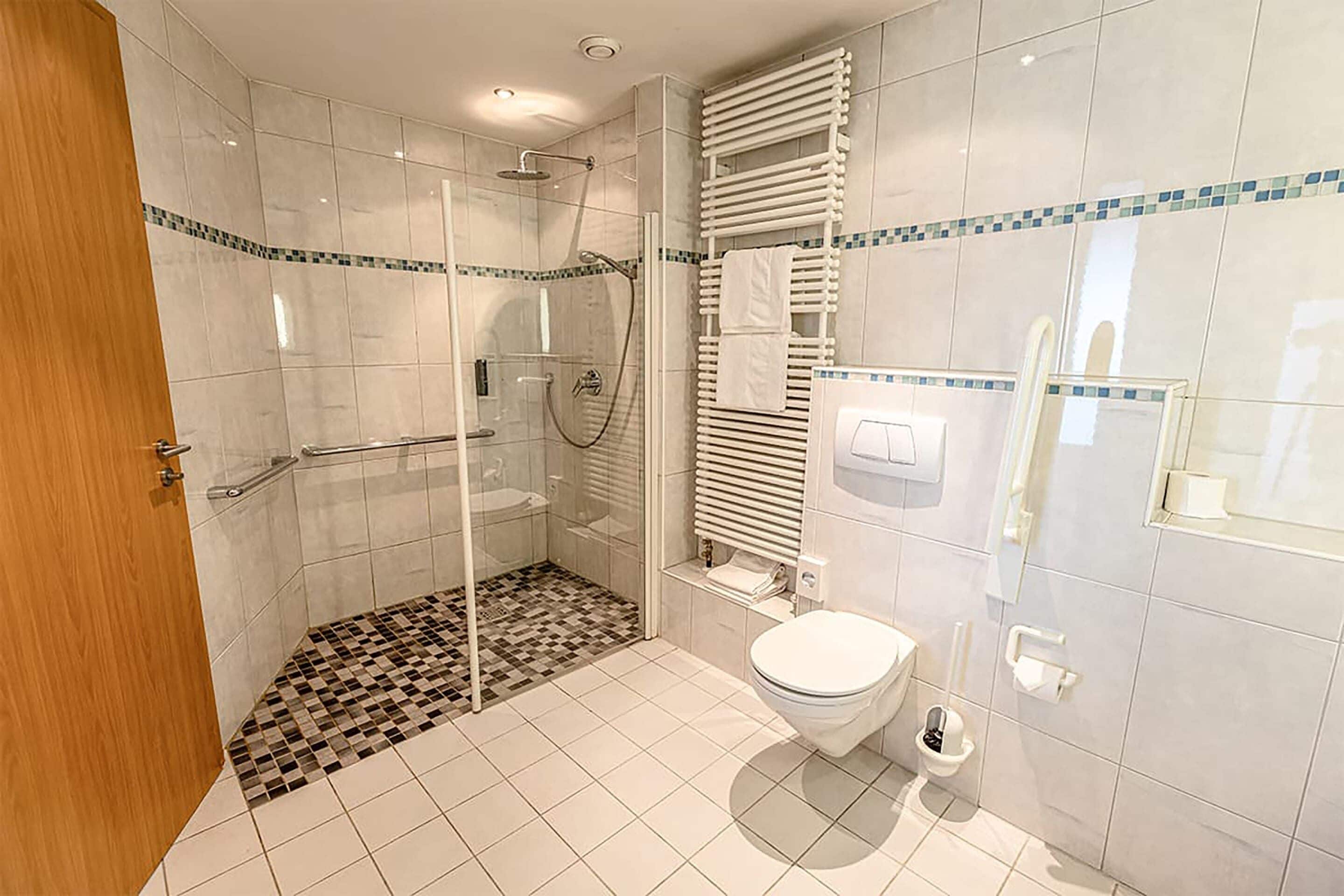 Ein modernes Badezimmer mit Duschkabine, Toilette und Waschbecken.