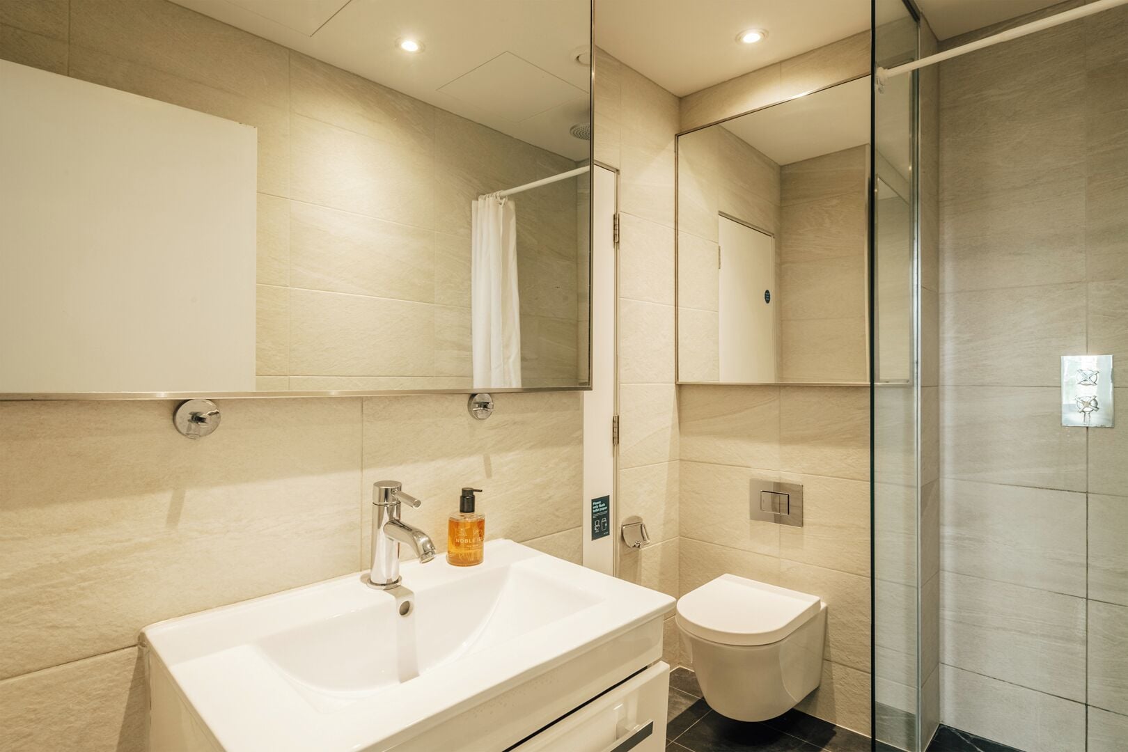 Ein modernes Badezimmer mit Waschbecken, Toilette und Duschkabine.