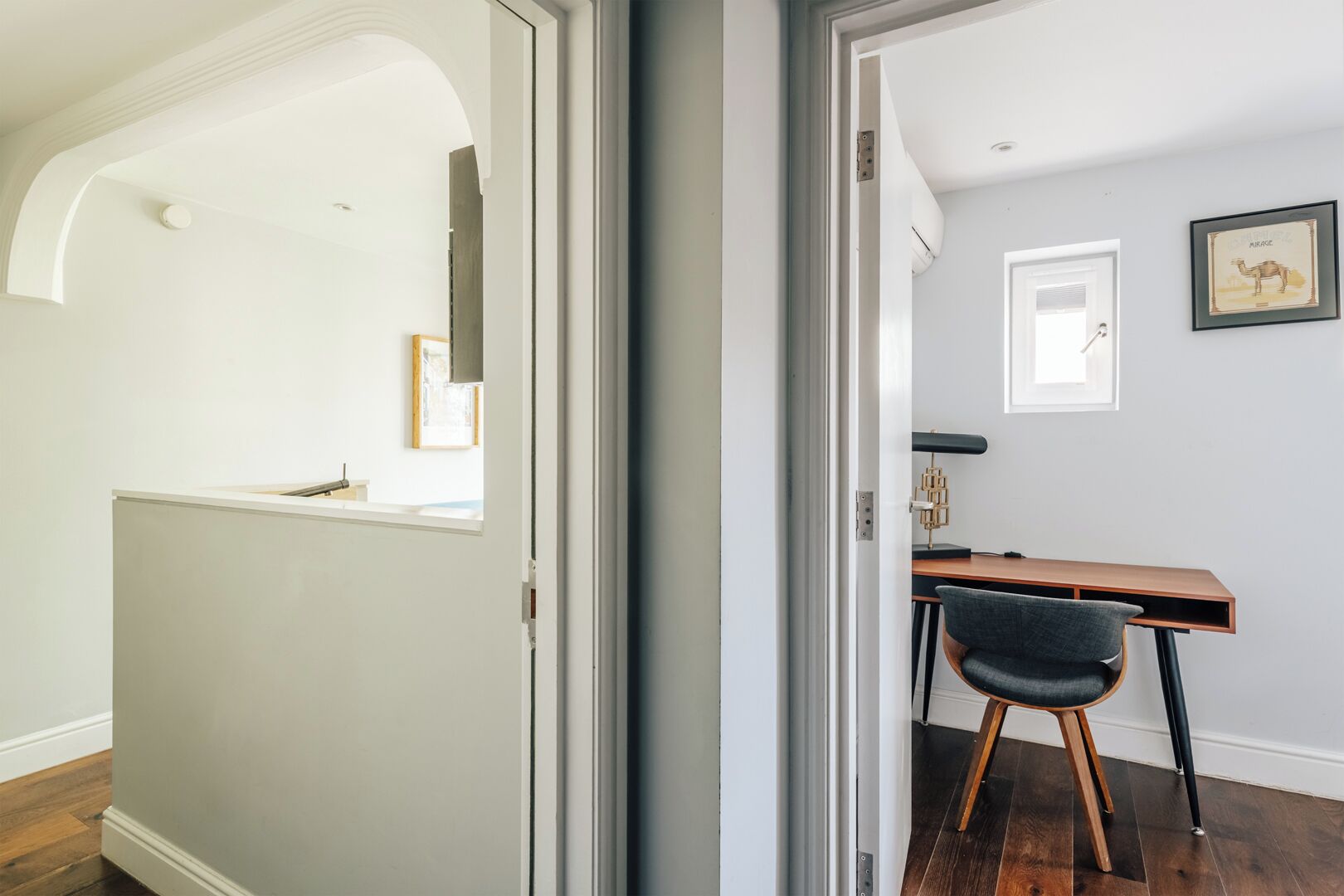 An interior space with a desk, chair, and framed picture on the wall.