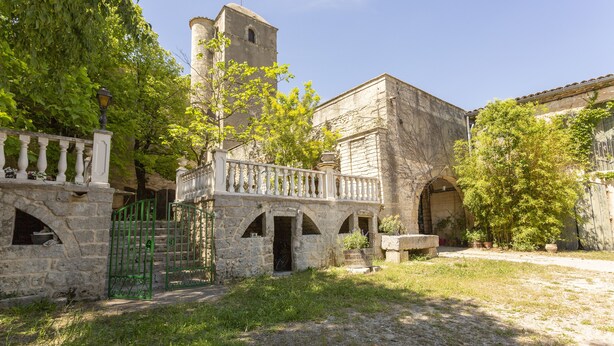 A courtyard with stone buildings, a tower, and a gate. - Mas du Crès (Galargues)
