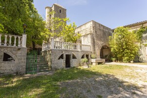 Un patio con edificios de piedra, una torre y una puerta.
