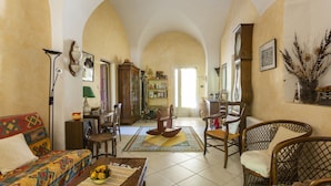 A cozy living room with a sofa, armchairs, a coffee table, and a bookshelf. - Mas du Crès (Galargues)