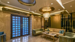 A spacious lobby with a marble floor, a large chandelier, and a modern sofa set. - Hotel Orient Regency (Mumbai)