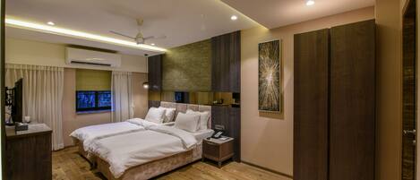 Una habitación de hotel moderna con una cama grande, un escritorio, un armario y un ventilador de techo.
