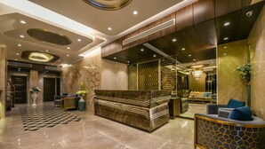 A modern lobby with a reception desk, seating area, and a staircase. - Hotel Orient Regency (Mumbai)