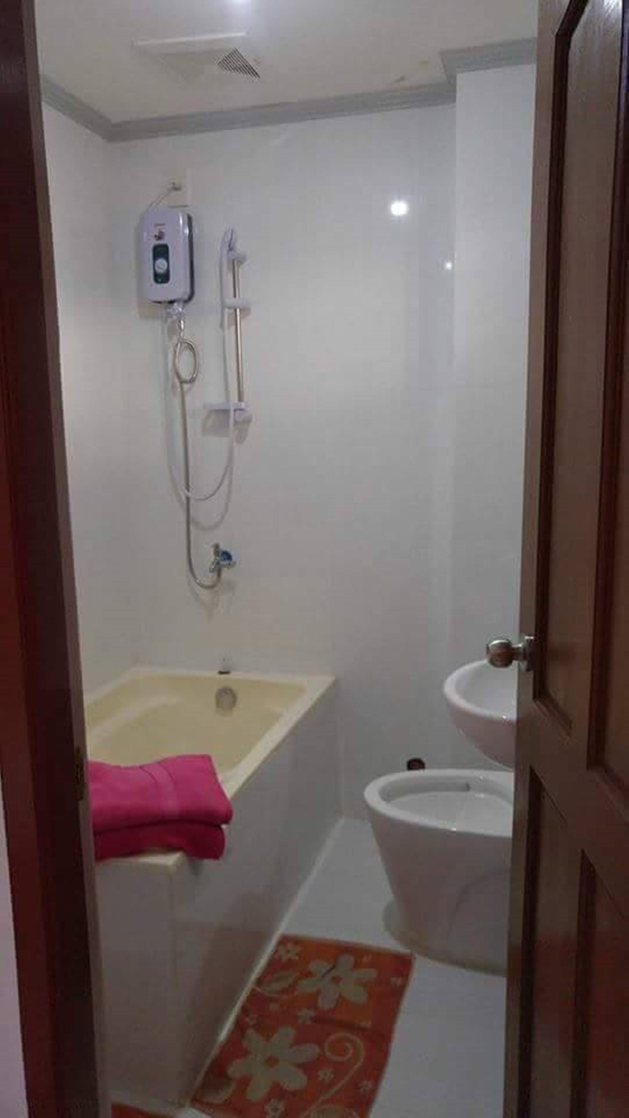 Un baño pequeño con bañera, inodoro y cabina de ducha.
