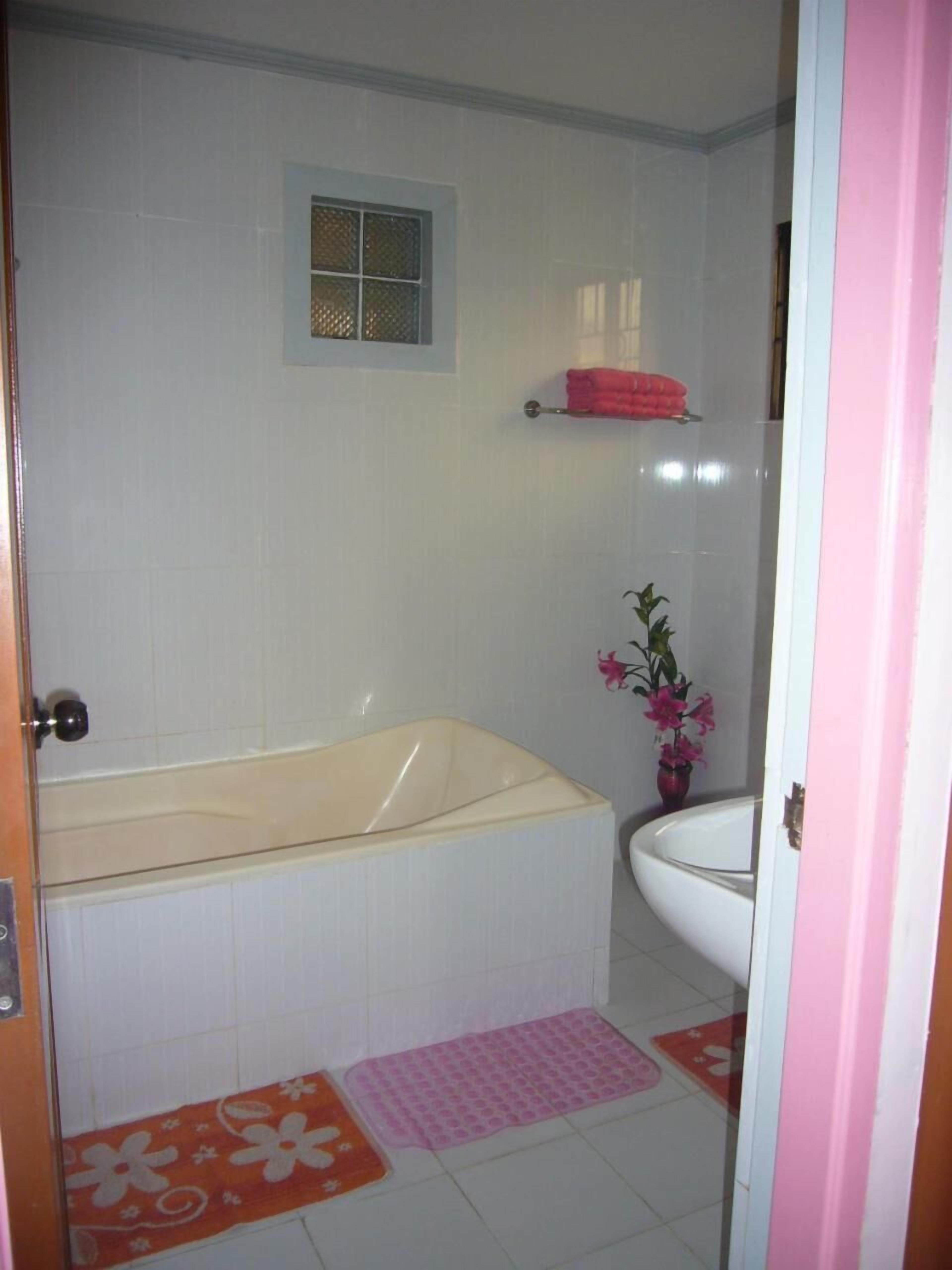 A bathroom with a bathtub, a sink, a toilet, and a shower area.