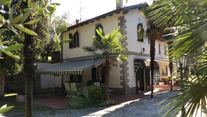 A villa with a patio, outdoor seating, and a gravel driveway. - Villa delle Sirene (Garda)