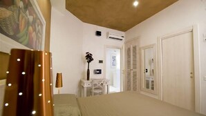 Une chambre d’hôtel équipée d’un lit, d’un bureau, d’une chaise, d’un climatiseur fixé au mur et d’une porte.