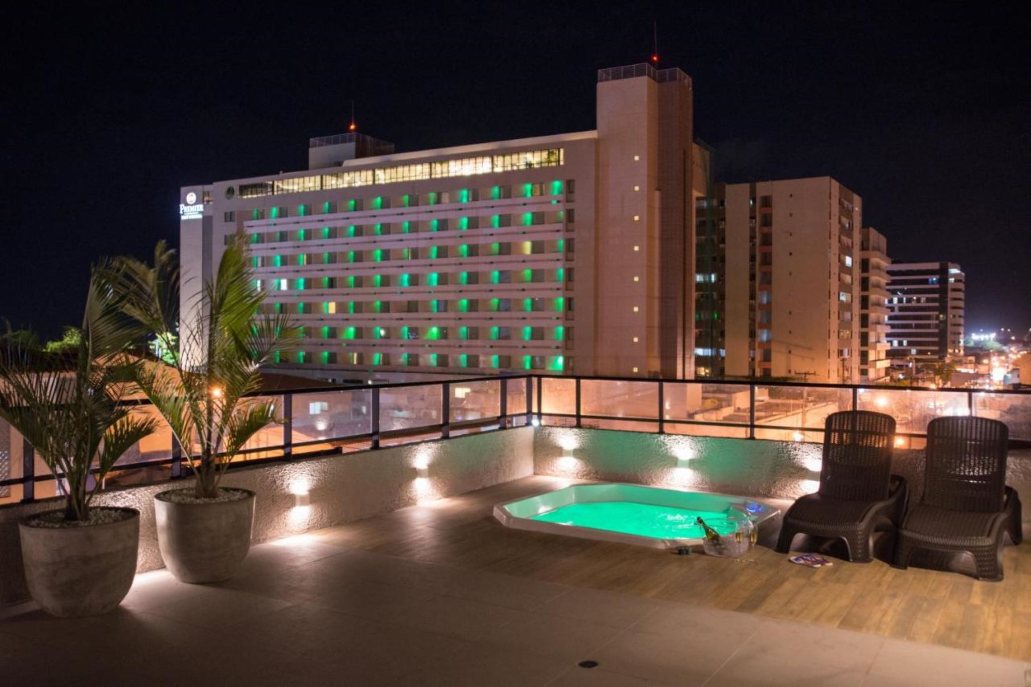 Zona de piscina en la azotea con vista a un edificio de hotel al fondo.