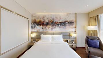 A hotel room with a large bed, two bedside tables, a chair, and a large abstract painting on the wall.