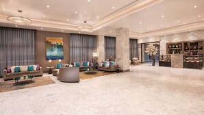 A spacious lobby with a marble floor, a large sofa set, a coffee table, and a display of jewelry. - Radisson Mumbai Andheri MIDC (Mumbai)