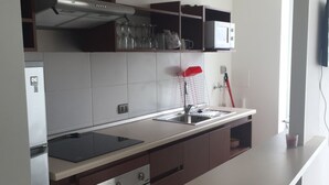 A modern kitchen with a built-in oven, a microwave, and a stainless steel range hood. - 13.- HNA Marina Sol 1 (Coquimbo)