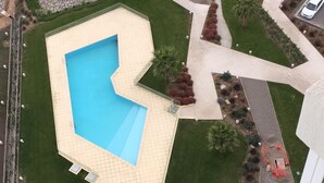 An aerial view of a residential area with a swimming pool, a fenced garden, and a road. - 13.- HNA Marina Sol 1 (Coquimbo)