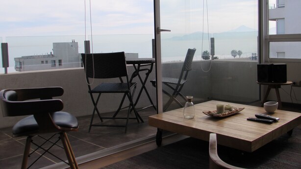 Un balcón con mesa, sillas y vistas de la ciudad.