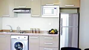 Una cocina moderna con un refrigerador de acero inoxidable, un microondas, un lavavajillas y una lavadora.