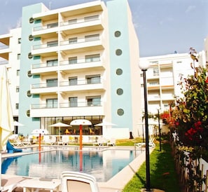 A modern hotel with a pool area, outdoor seating, and a garden. - L'escale Suites Residence Hoteliere (Mohammedia)