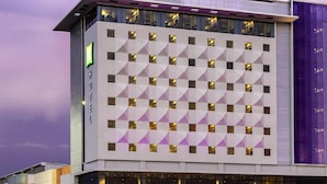 A modern hotel building with a geometric facade, large windows, and a prominent 'ibis Styles' sign. - ibis Styles Merida Galerias (Mérida)