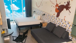 A hotel room with a bed, a sofa, a desk, and a bathroom. - ibis Styles Merida Galerias (Mérida)