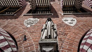 Un bâtiment à la façade en briques, doté d’auvents rayés et d’une entrée centrale ornée d’un blason.