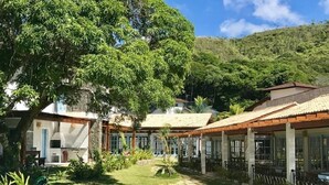 Ett semesterområde med flera byggnader i bungalowstil, en central gångväg och frodig grönska.