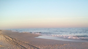 Ein Strand mit sandigem Ufer und sanften Wellen.