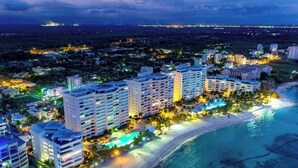 Ein Küstenhotel mit mehreren Hochhäusern, einem Strandzugang und einem Swimmingpool.