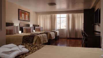 Standaard vierpersoonskamer, meerdere bedden | Luxe beddengoed, een minibar, een bureau, een laptopwerkplek