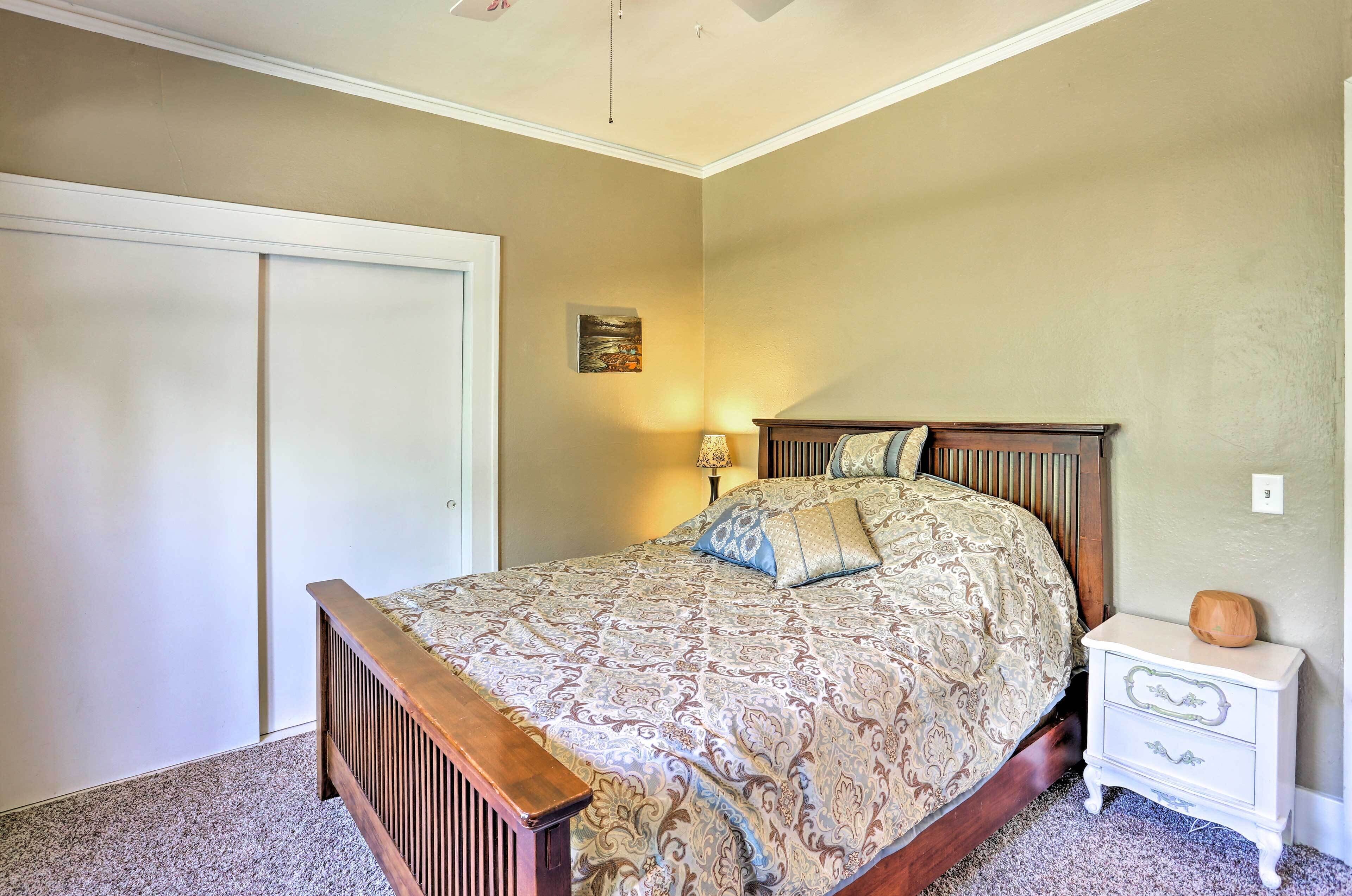 Ein Schlafzimmer mit Bett, Nachttisch, Lampe und einer Tür.