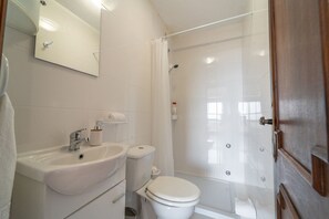 Bathroom features a sink, toilet, and glass-enclosed shower area.