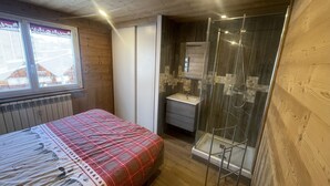 Une chambre à coucher avec un lit, une fenêtre, une douche et une salle de bain.