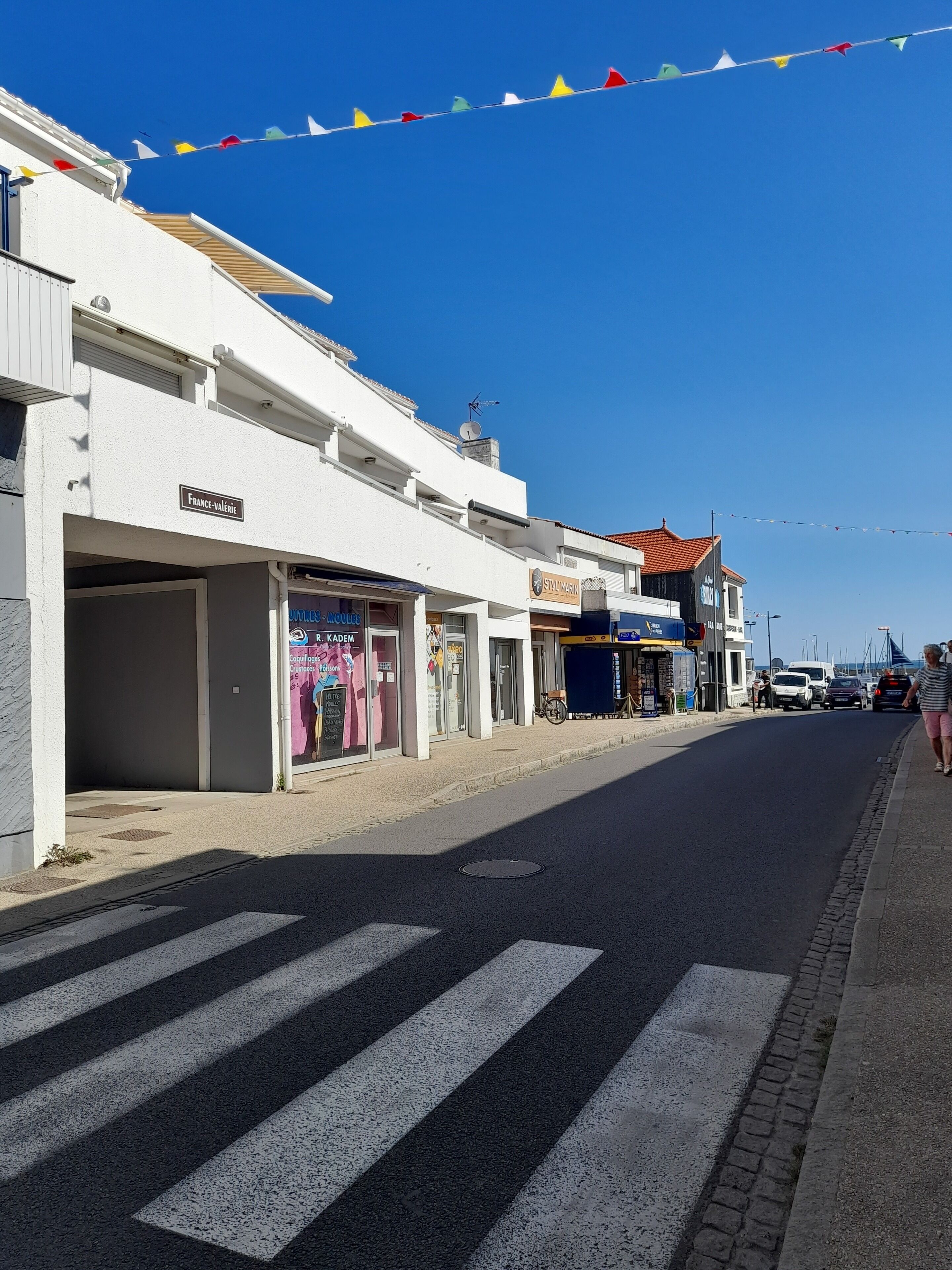 A street with shops, including a visible storefront with a sign that reads "FRANCE-VALERIE".