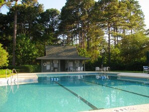 A swimming pool with clear water, surrounded by trees and a small building with a roof. - SUPER VALUE VACATION HOUSE: PRIVATE BEACH, GOLF, POOL, BIKES
 (Hilton Head)