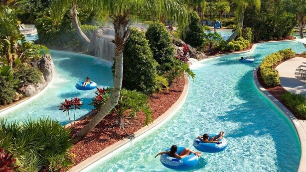 A water park with a winding pool, trees, and people on inflatable tubes. - SUPER VALUE VACATION HOUSE: PRIVATE BEACH, GOLF, POOL, BIKES
 (Hilton Head)