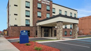 A Cobblestone Inn & Suites building with a brick facade, a covered entrance, and a parking lot. - Cobblestone Inn & Suites - Ashland (Ashland)