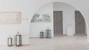 A spacious hallway with an arched ceiling, a tiled floor, and a few wall-mounted lanterns. - Melian Boutique Hotel & Spa (Milos)