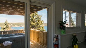A balcony with a hot tub, wooden deck, and a view of the water. - Whale House Guest House (Mobile)